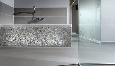 Betonlook gietvloer in badkamer met Stones Design bad afwerking.